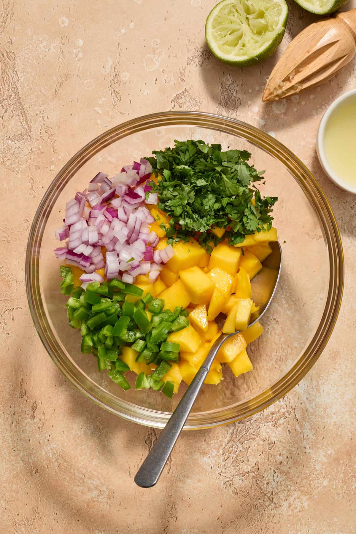 Mango salsa ingredients in glass bowl before mixing.