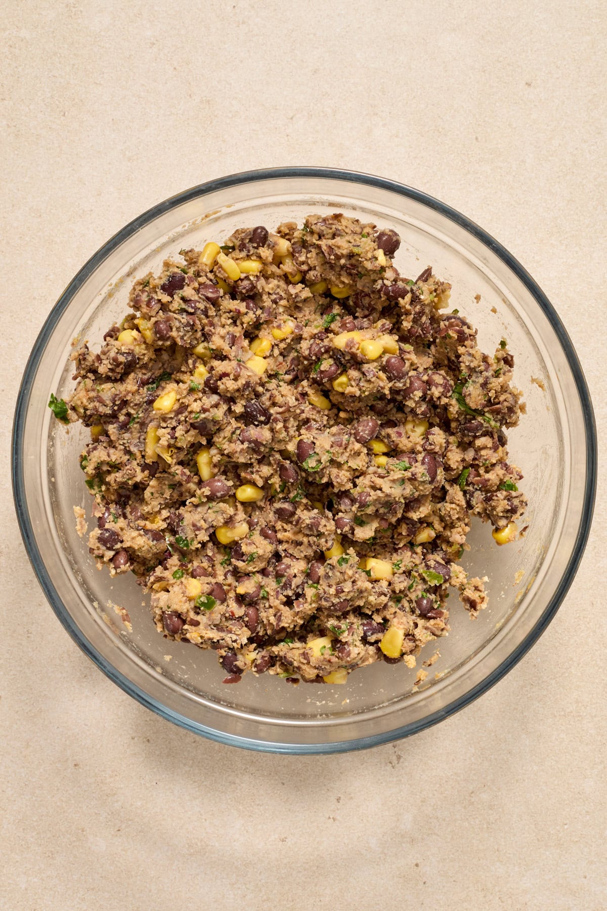 Spicy black bean burger mixture in glass mixing bowl.