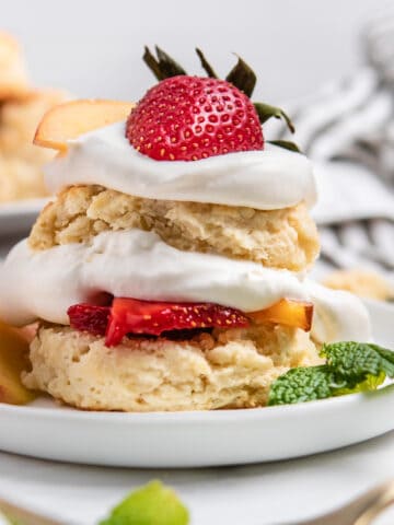 Peach Shortcake with fresh whipped cream on plate.