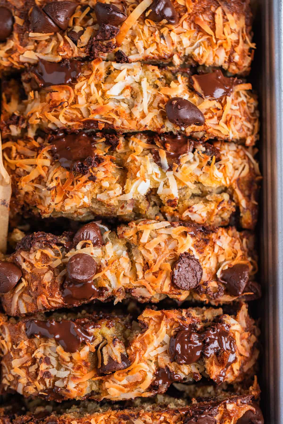 Slices of coconut topped banana bread with dark chocolate chips on top.
