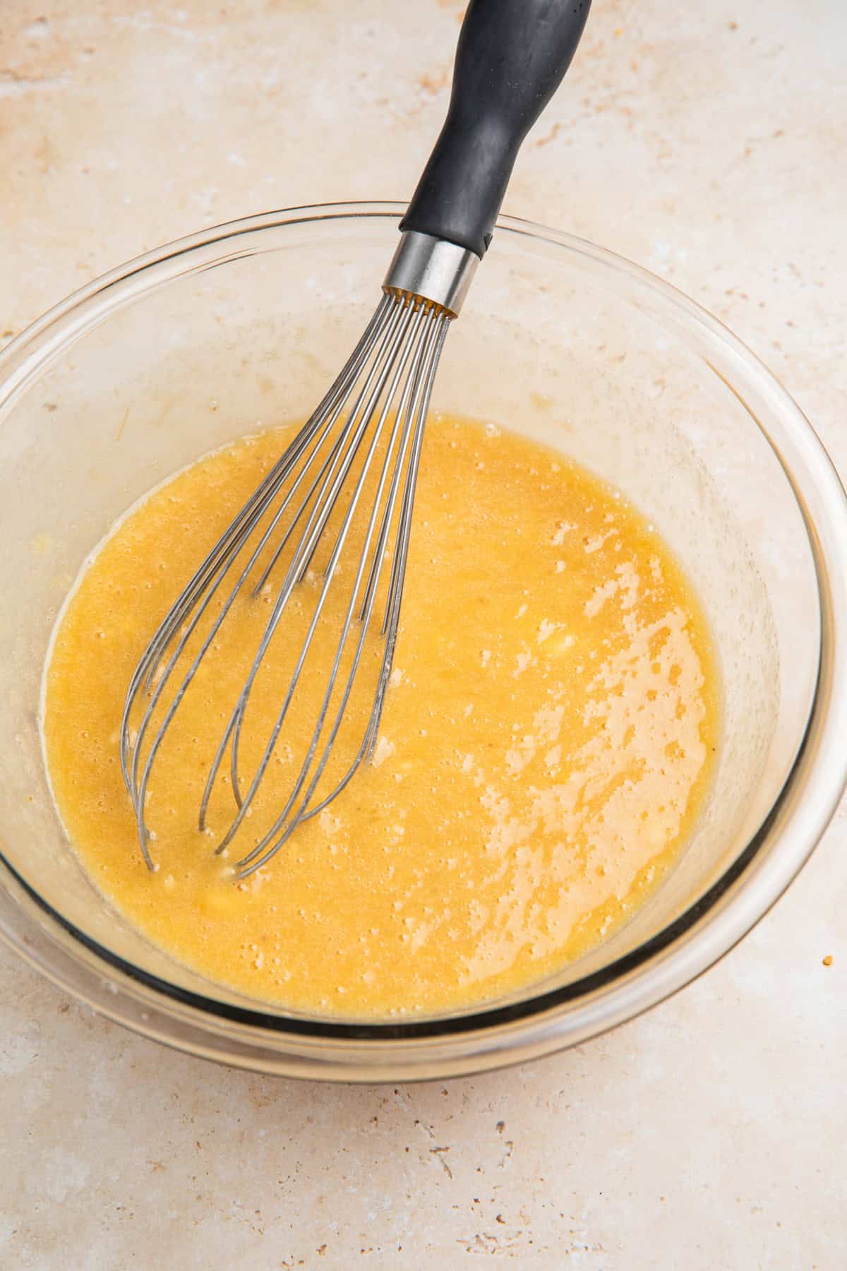 Whisked butter, banana, eggs and sugars in bowl.