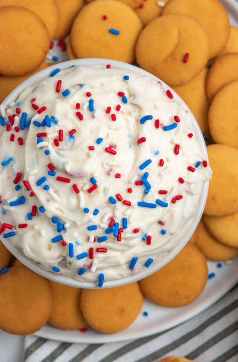 Overhead view of funfetti dip with red, white and blue sprinkles and vanilla wafers.