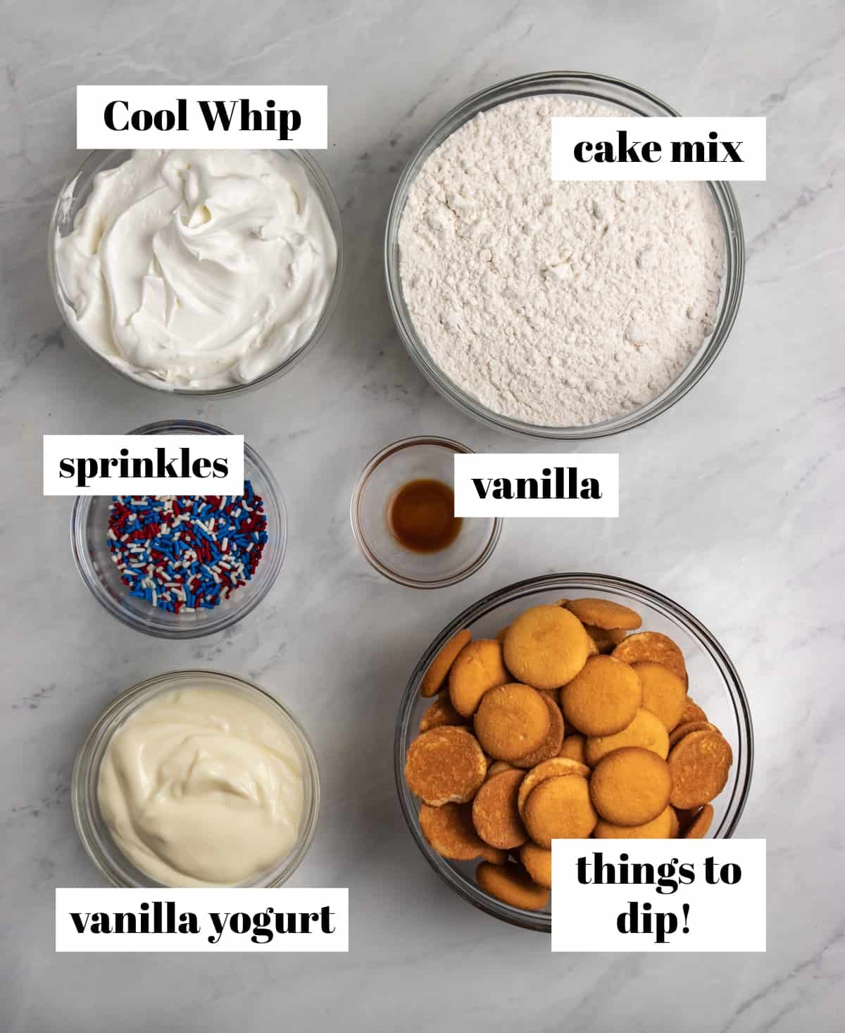 Cool whip, sprinkles, vanilla and cake mix labeled on counter.
