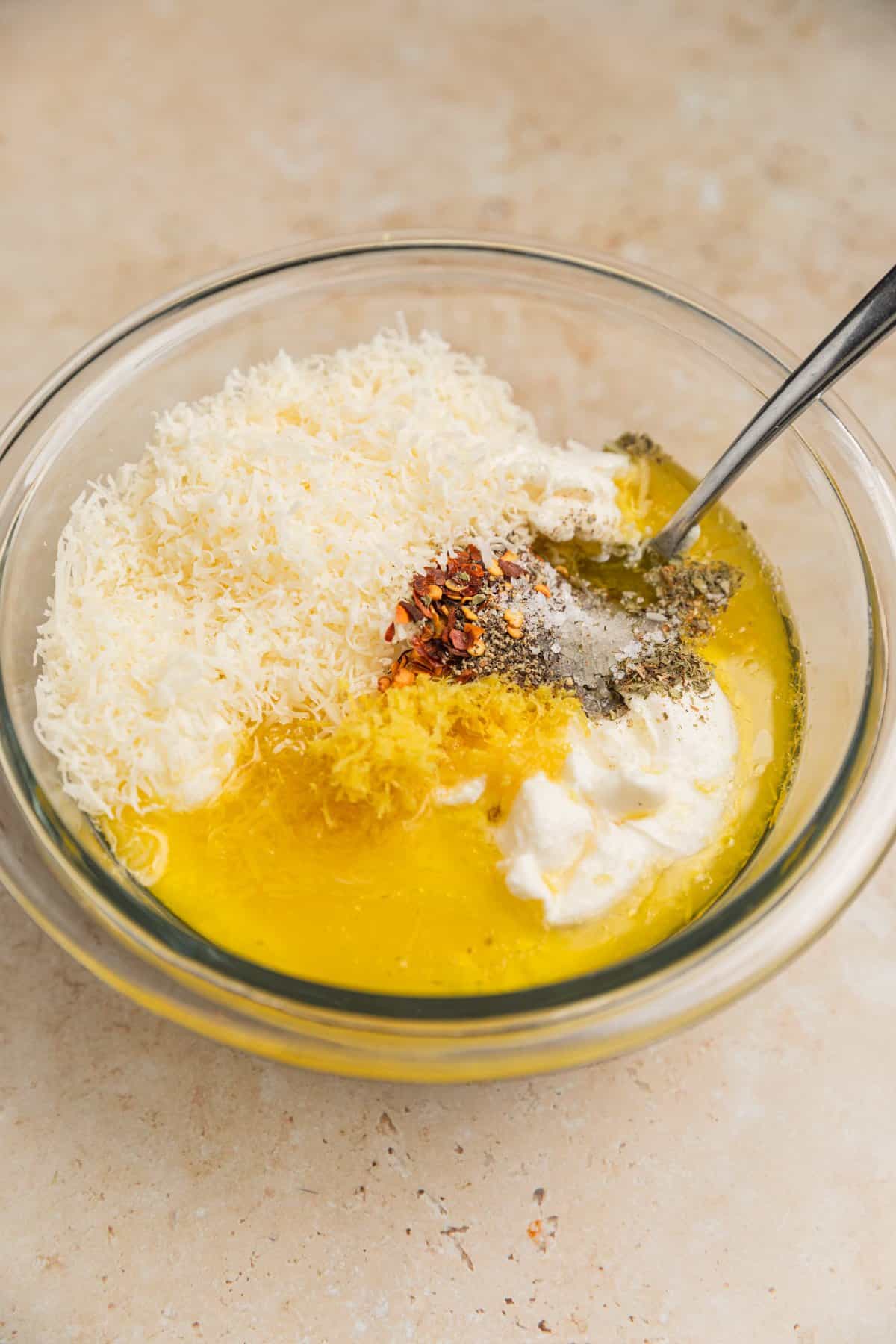 Lemon zest, parmesan, ricotta, olive oil and other ingredients added to bowl.
