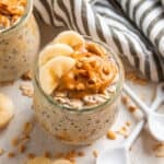 Glass jar with overnight oats topped with sliced banana and topped with peanut butter.