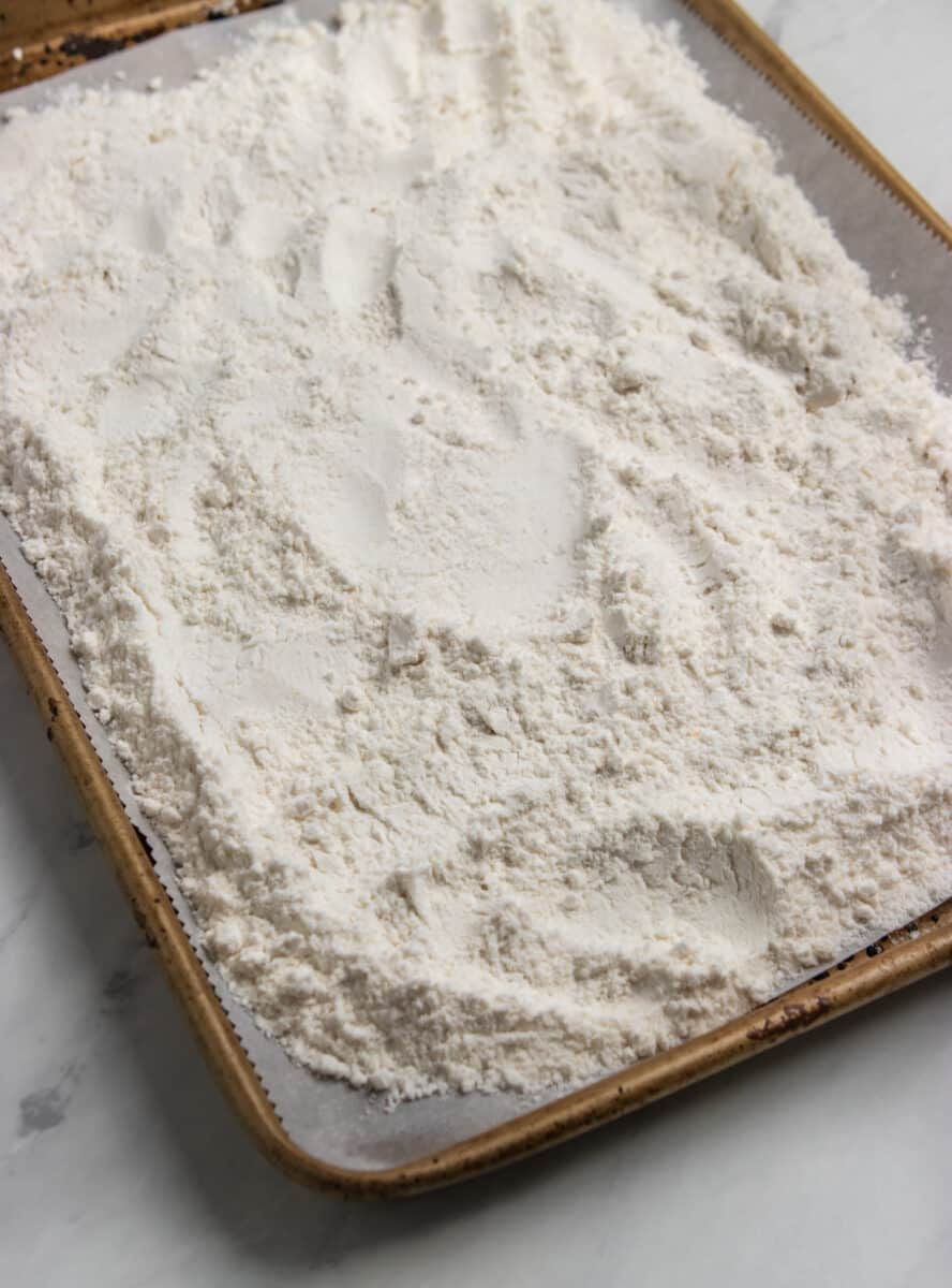 Sheet pan with cake mix spread evenly over top.
