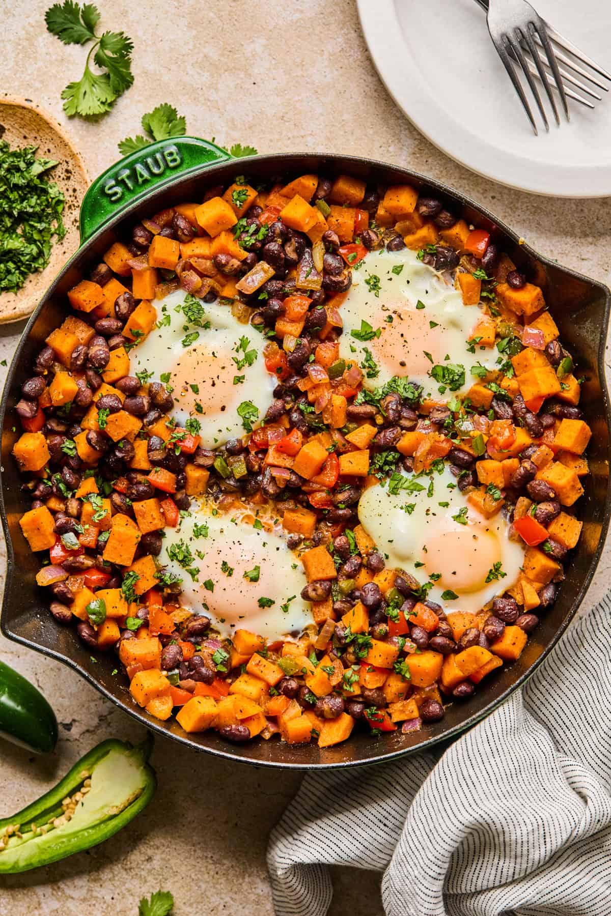 Sweet potato black bean breakfast hash in skillet with cilantro garnish over top.