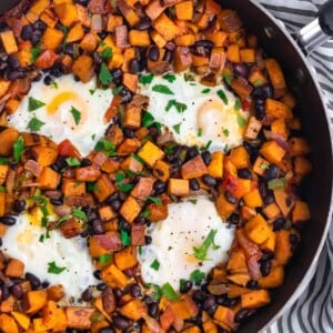 Sweet potato and black bean hash in skillet with eggs.