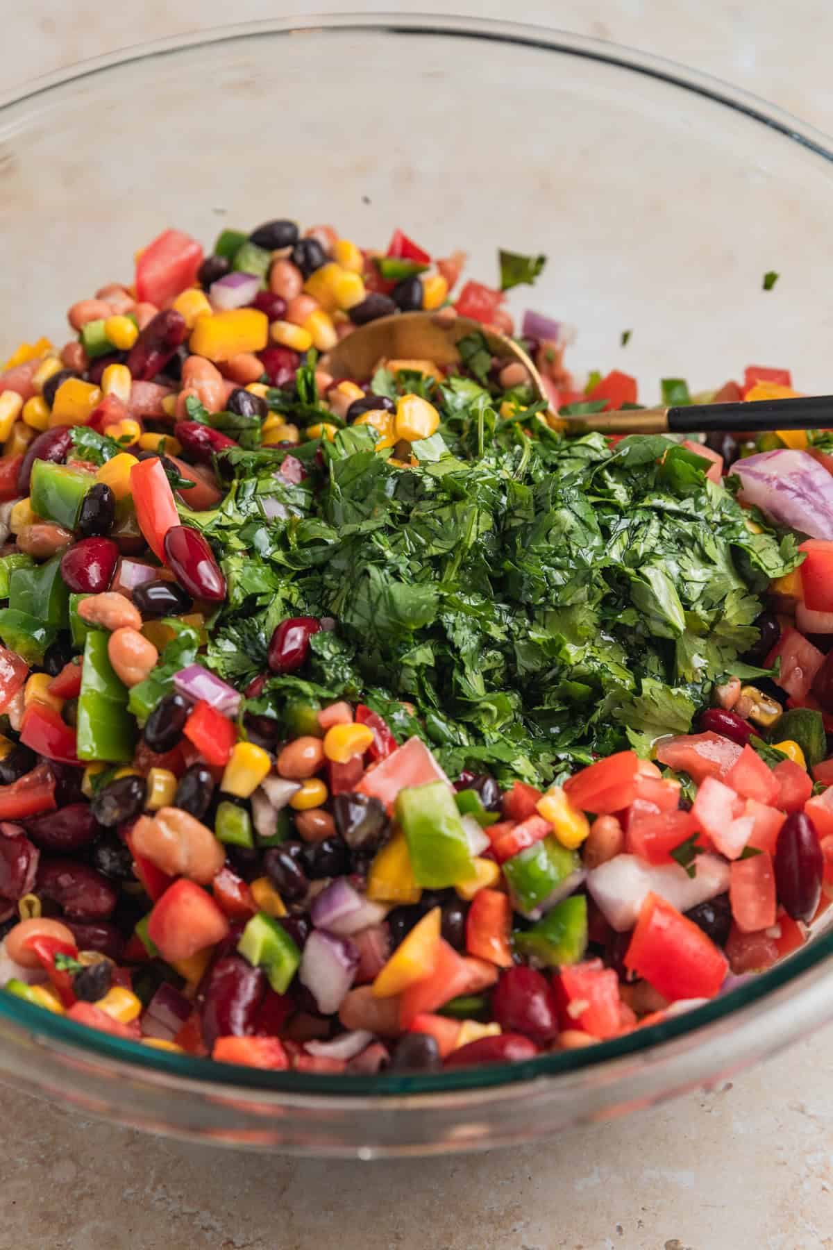 Cilantro chopped and added to mixing bowl with prepped bean and corn salad.