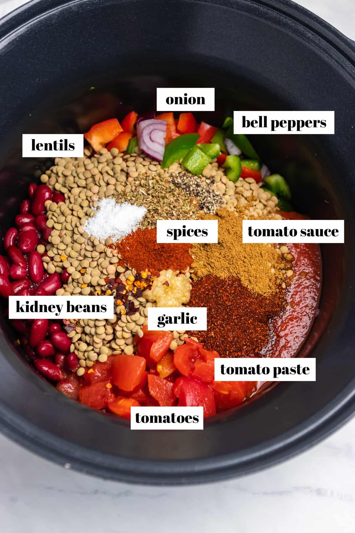 Crock pot with lentil chili ingredients labeled.