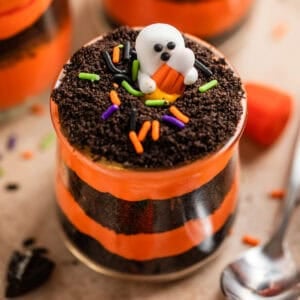 Oreo Halloween dirt cake layered in glass cup with ghost candy on top.