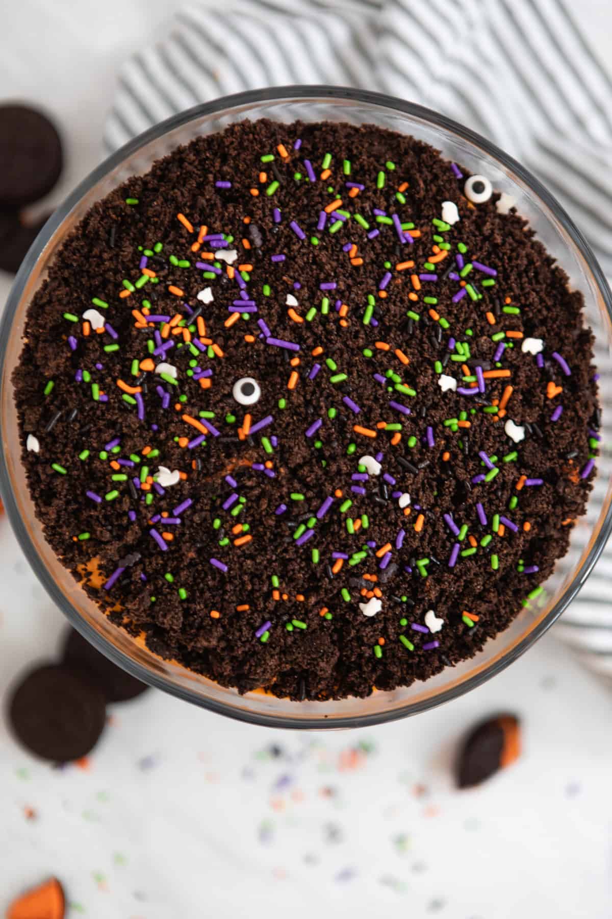Overhead view of Halloween Dirt Cake in trifle bowl with sprinkles.