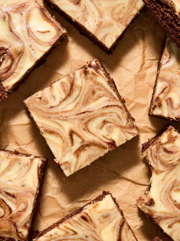 Kahlua brownies with cheesecake swirls on top sliced and arranged on parchment.