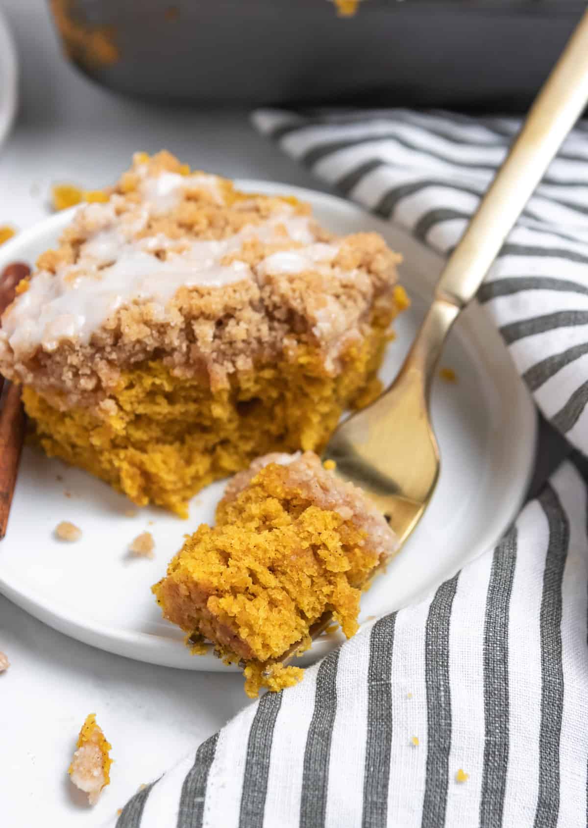 Forkful of pumpkin coffee cake on plate.