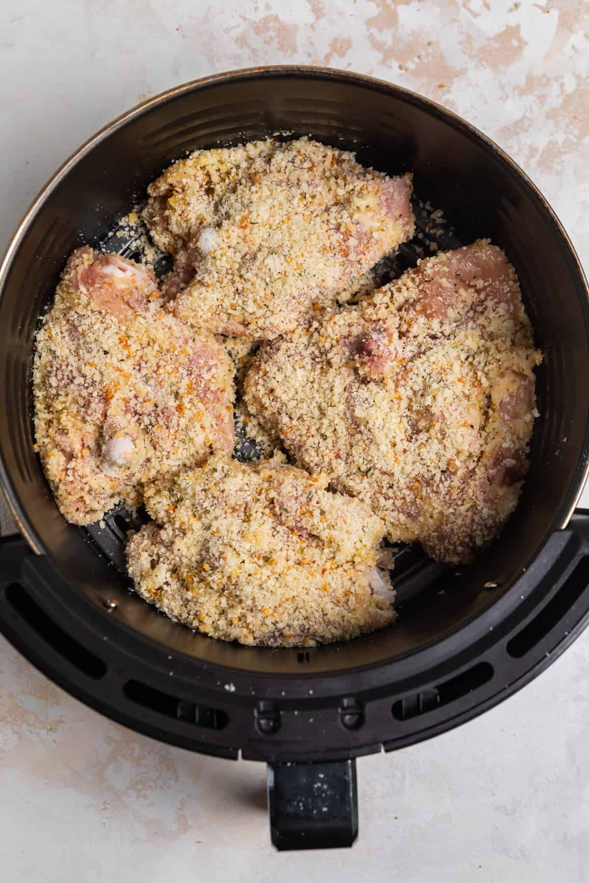 Overhead view of parmesan crusted chicken thighs in air fryer
