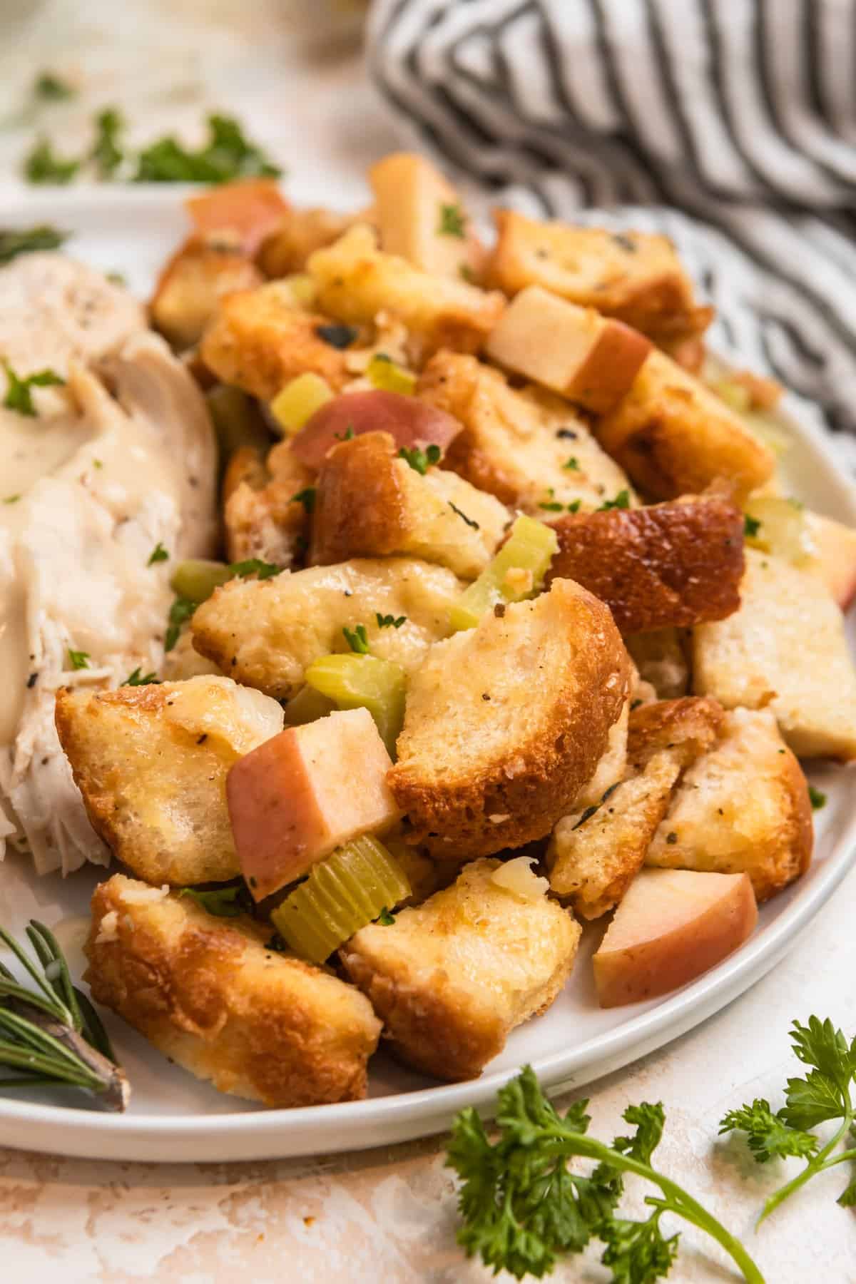 Apple stuffing on white plate with turkey.