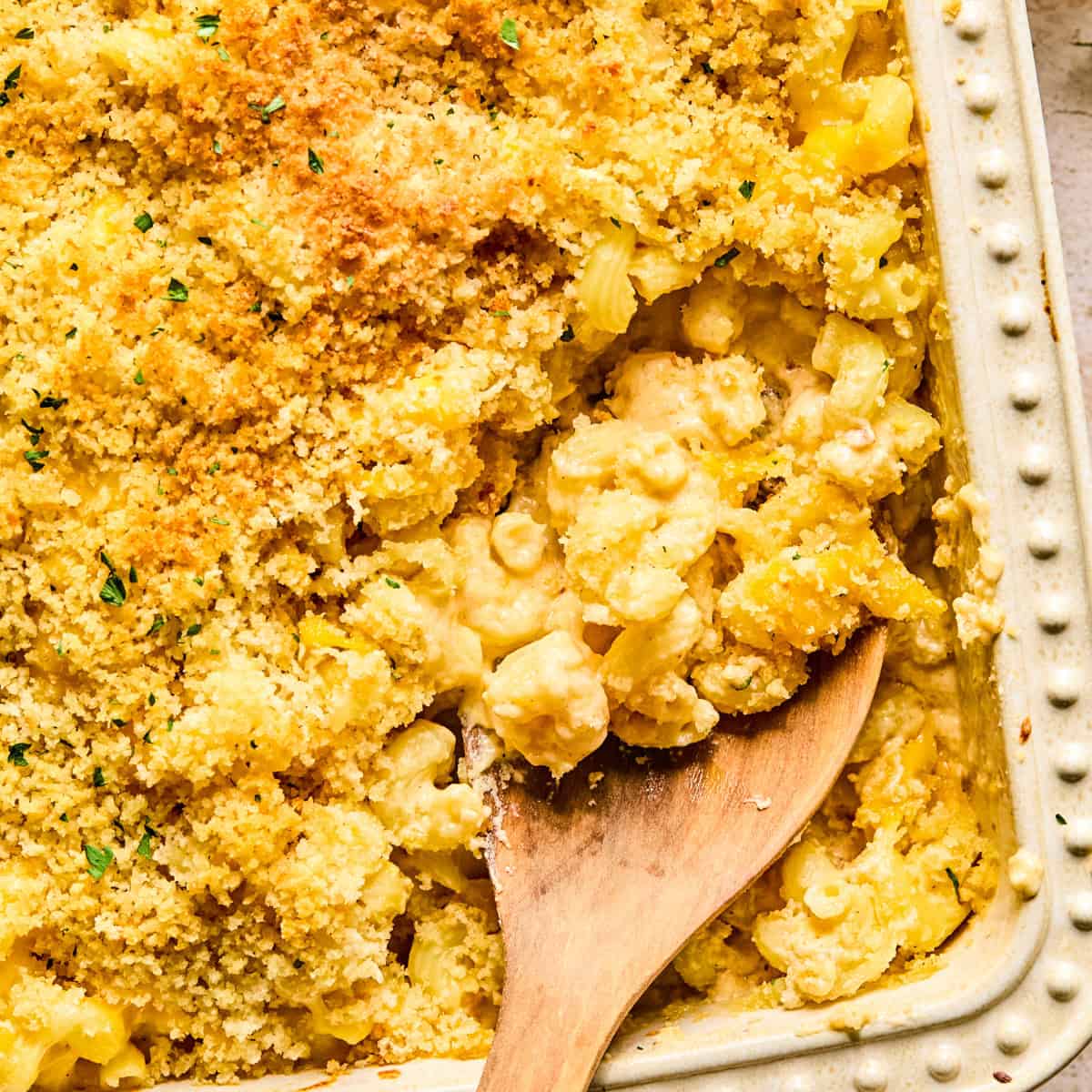 Macaroni and cheese in pan baked with breadcrumbs and chopped parsley on top.