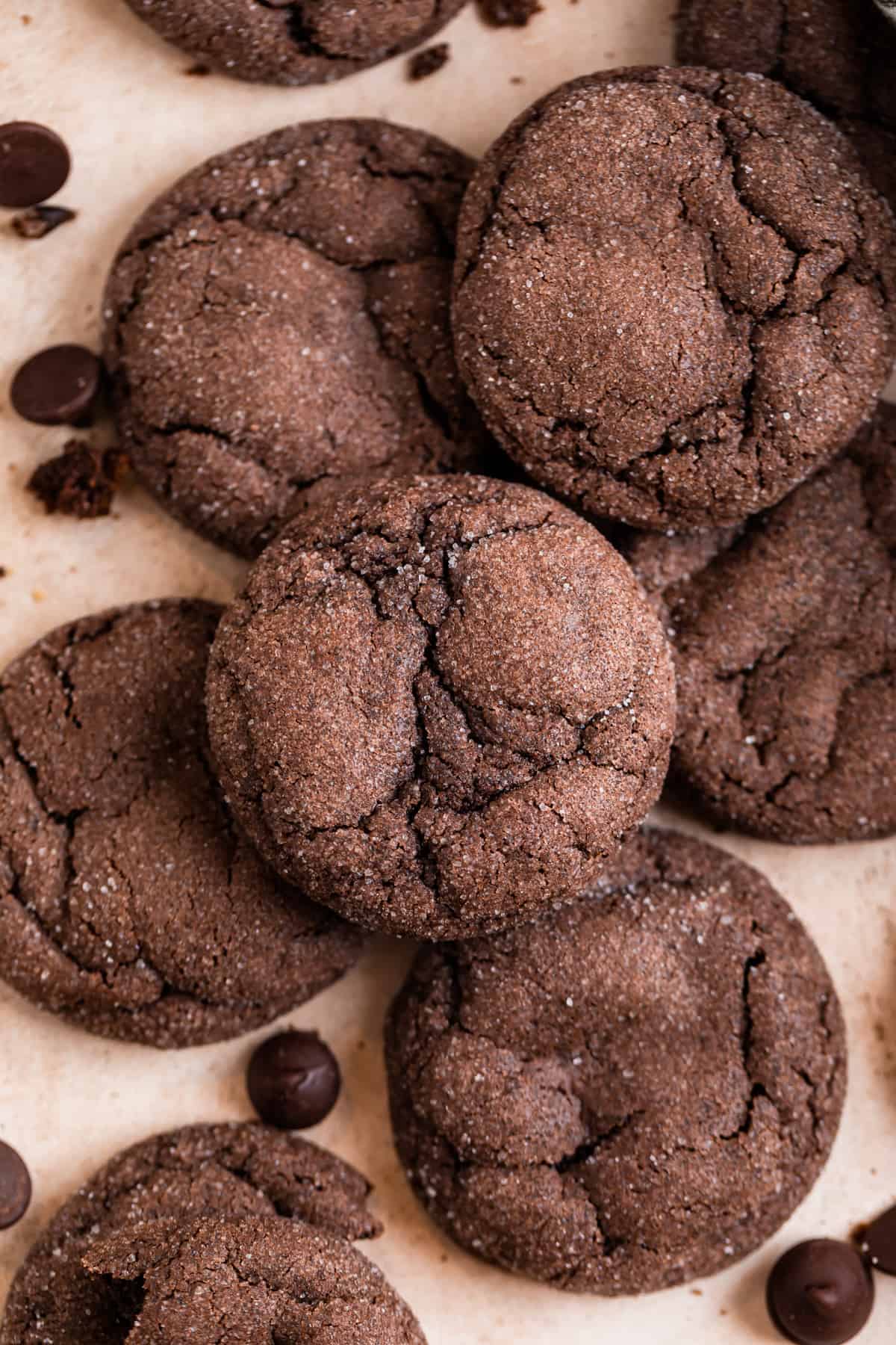 Chocolate cookies arranged on counter with chocolate chips and crumbs surrounding.