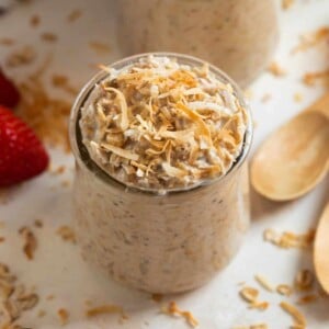 Coconut cream pie overnight oatmeal in a jar topped with toasted coconut.
