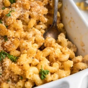 Casserole dish with mac and cheese and serving spoon.