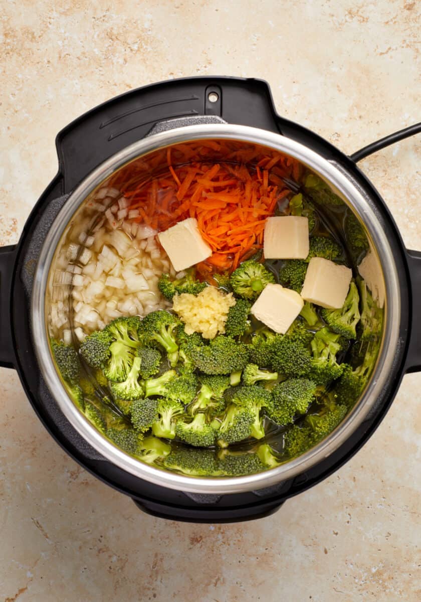 Broccoli, shredded carrots, onion, butter and garlic in Instant Pot.