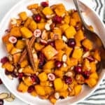 Overhead view of white bowl with maple roasted butternut squash.