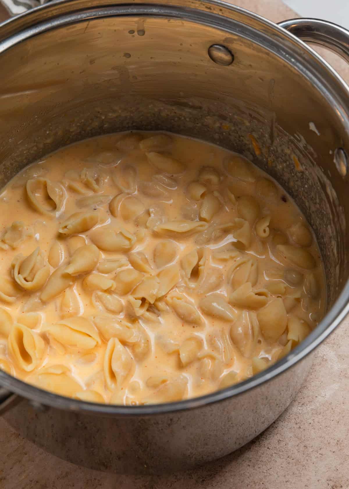 Pasta added and stirred into large pot with cheese sauce.