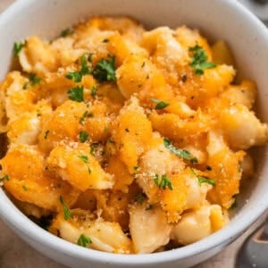 Bowl with protein mac and cheese with chopped parsley over top.