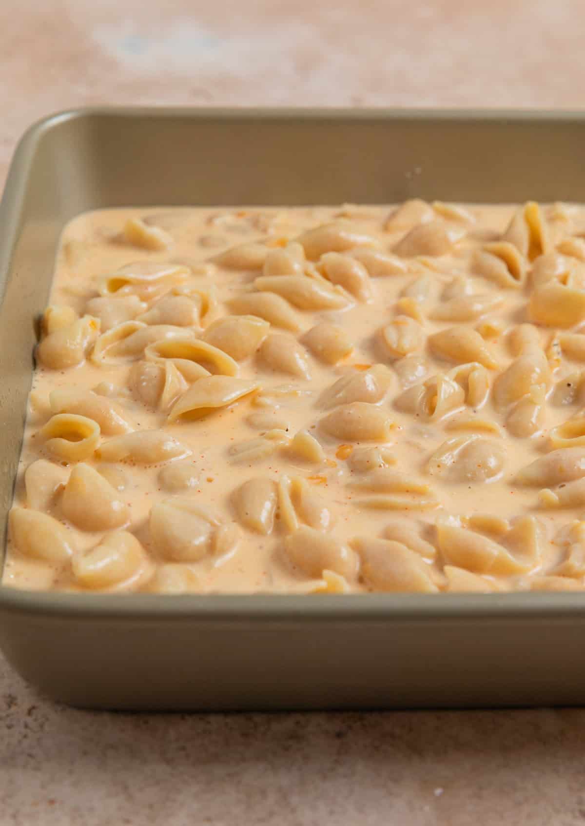 Protein macaroni and cheese mixture in square baking pan before baking.