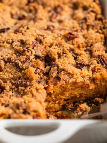 Casserole dish with baked brioche French toast casserole topped with pecan streusel.