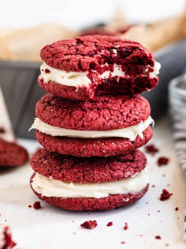 Stack of red velvet cake mix cookies with bite taken out of top cookie.