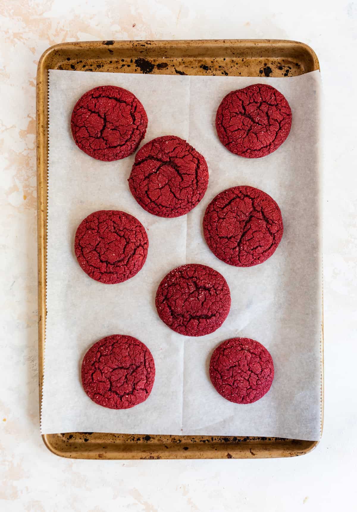 Baked red velvet cake mix cookies on cookie sheet.