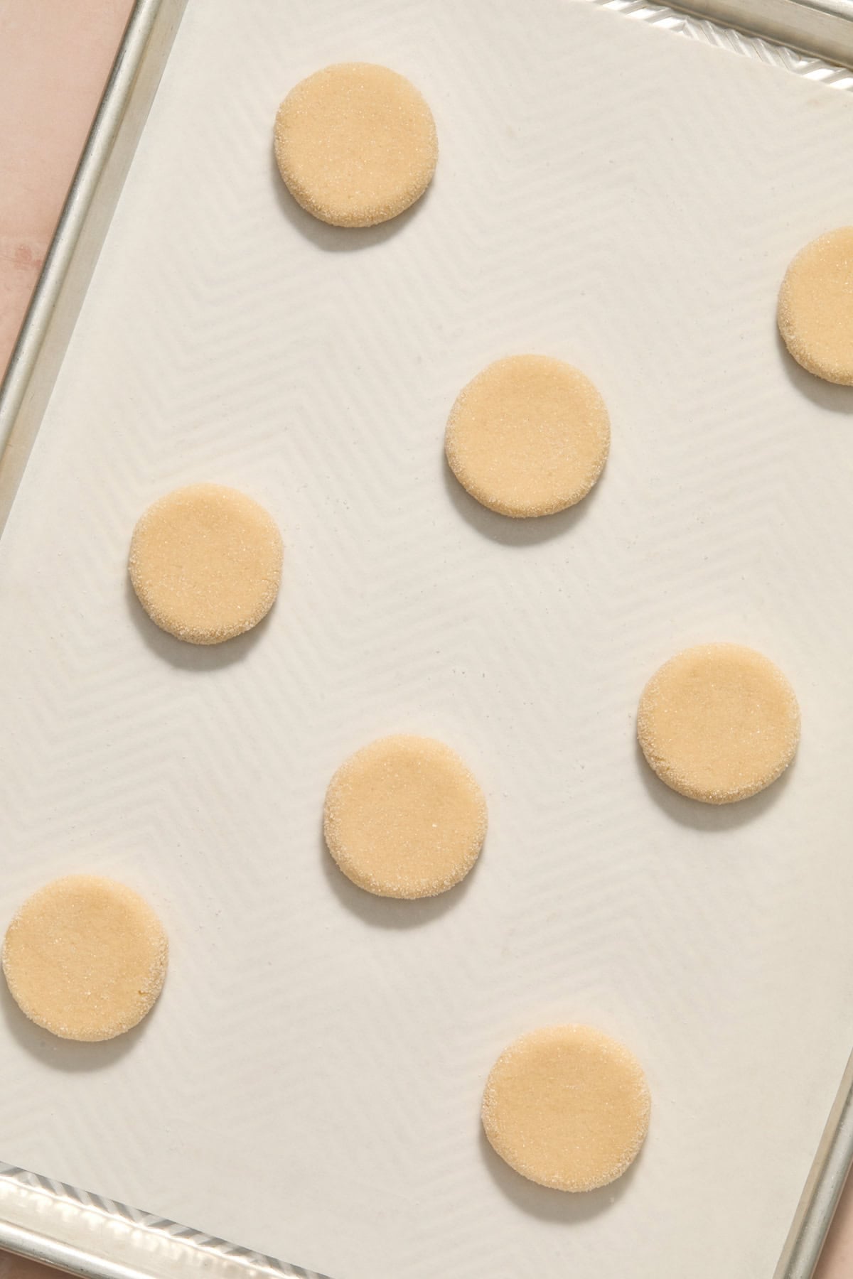 Cookie dough pressed gently on pan with parchment.