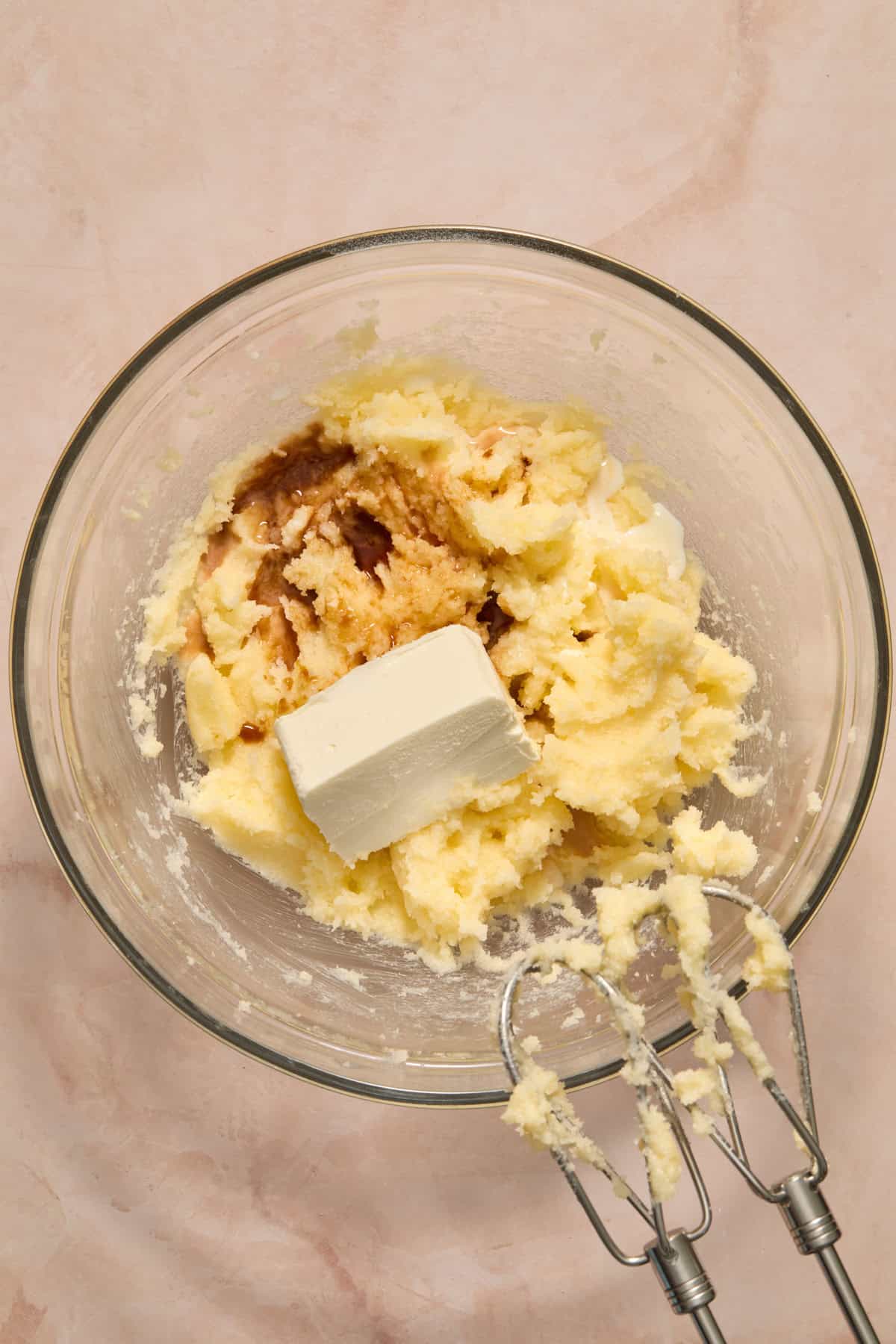 Creamed butter and sugar in bowl with cream cheese and vanilla added into bowl.