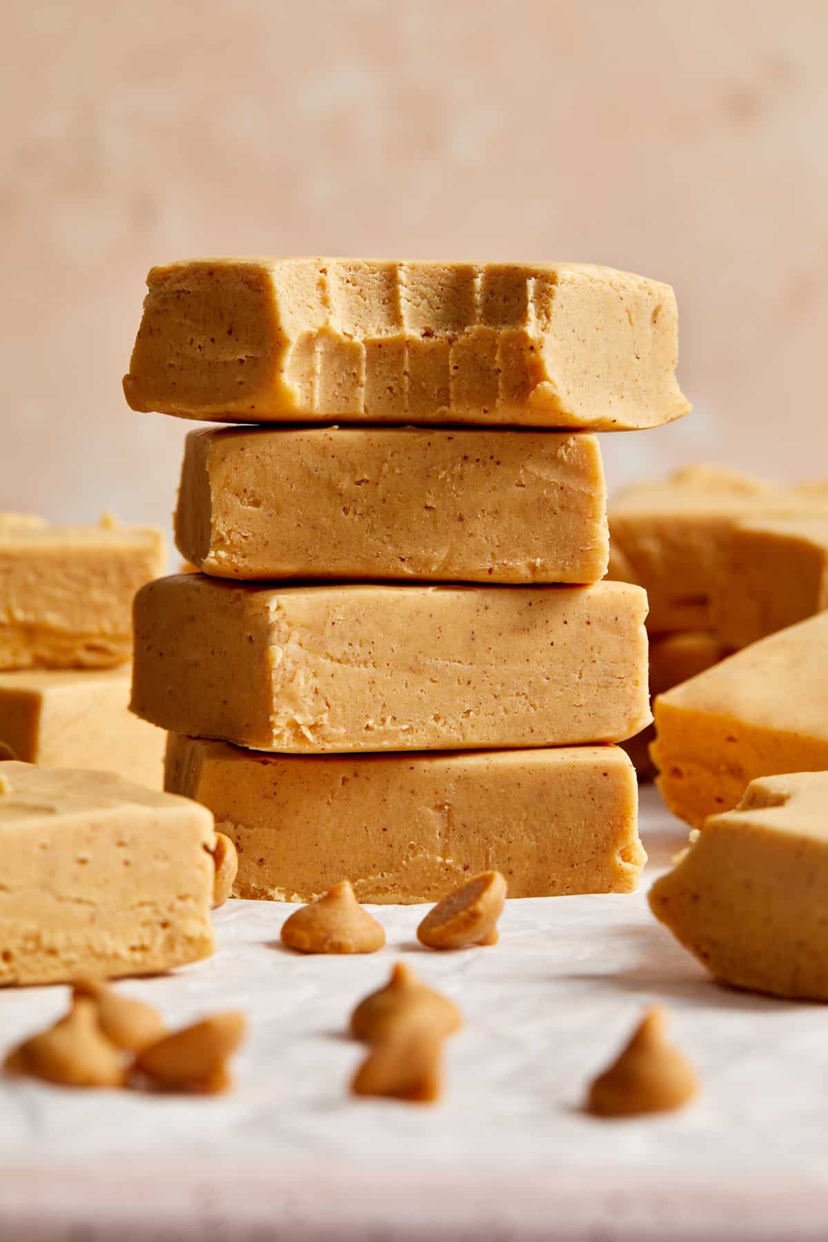 Stack of cut microwave peanut butter fudge pieces with top piece bitten into.