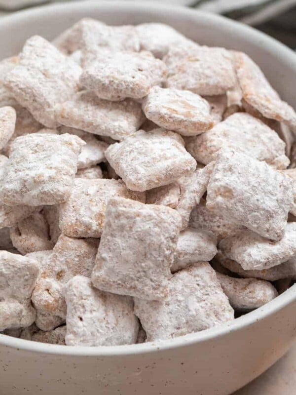Cinnamon puppy chow chex mix in white bowl.