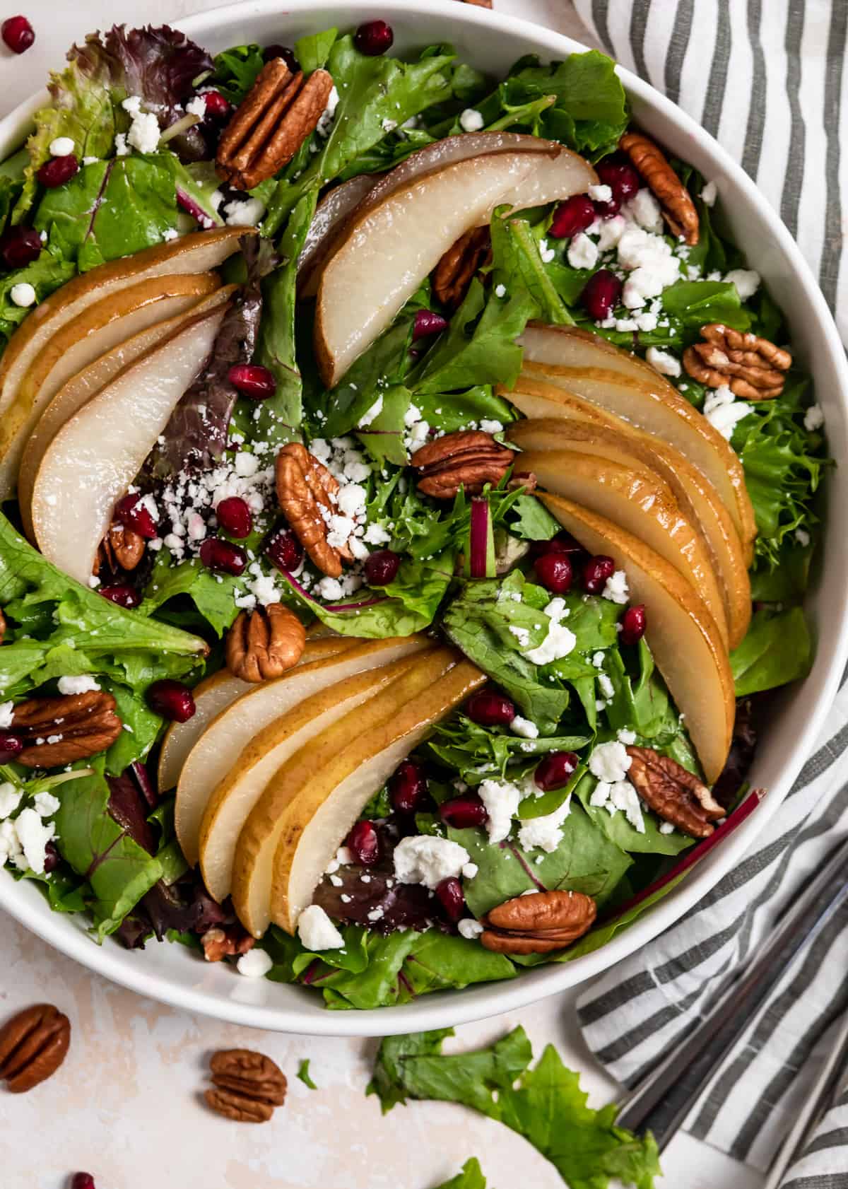 Overhead view of white bowl with pear salad.