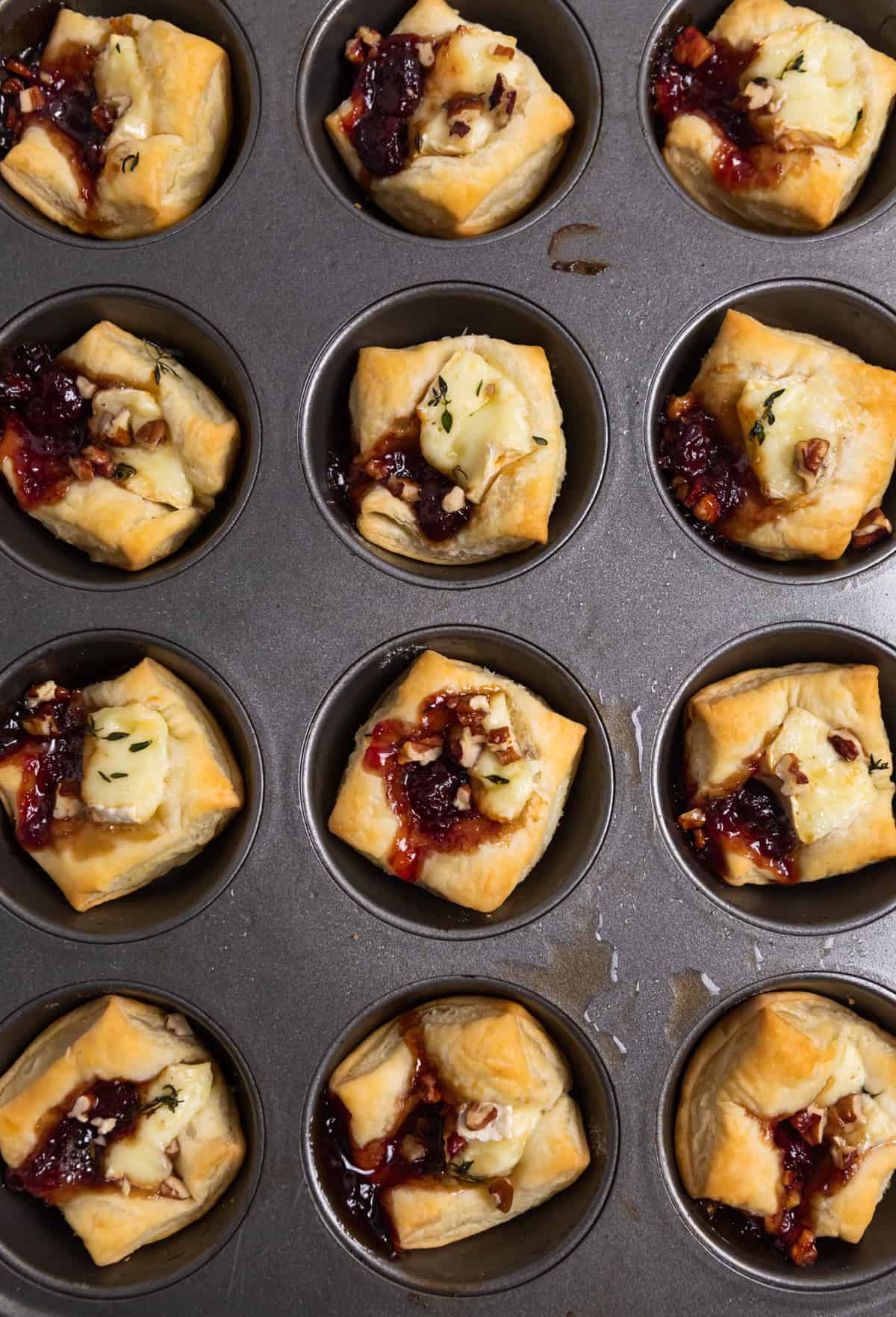 Overhead view of muffin tin with puff pastry brie bites.