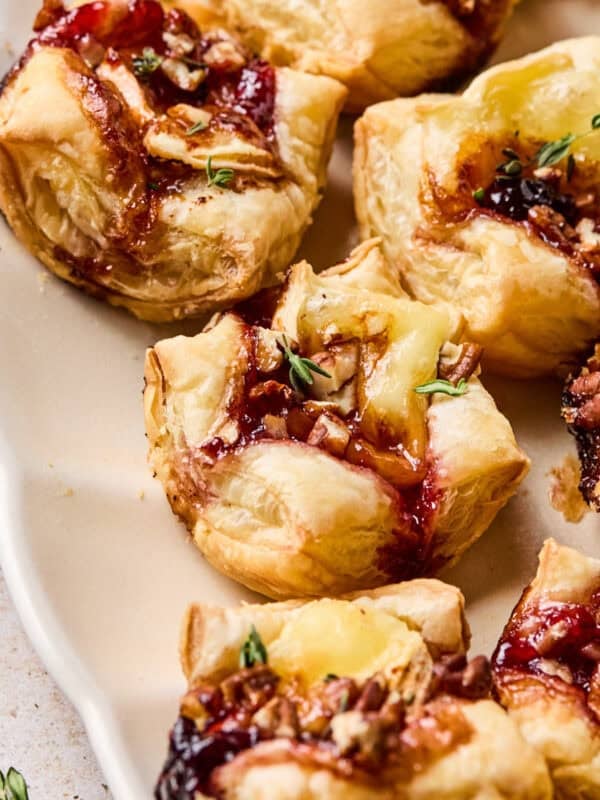 Puff pastry brie bites on serving platter.