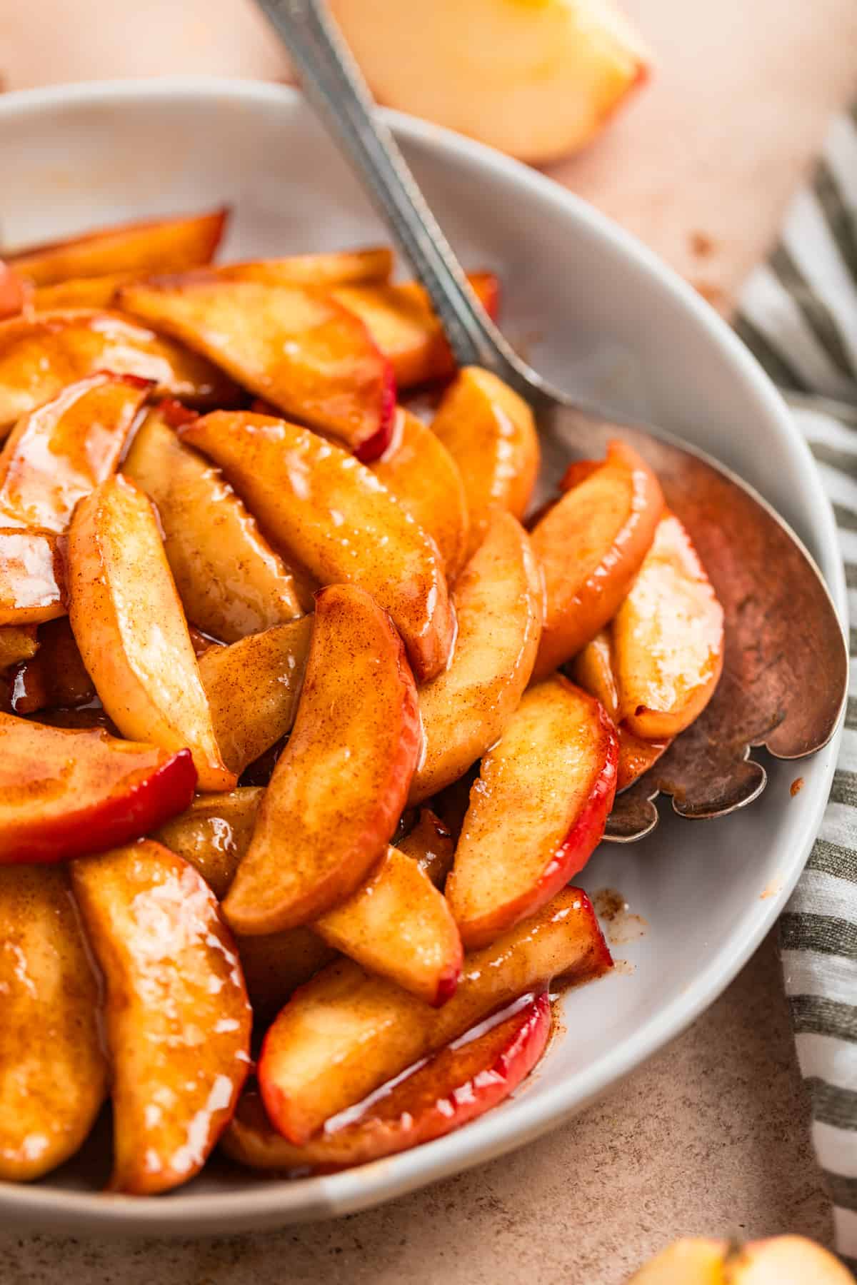 Dish with cinnamon air fryer apples with serving spoon.