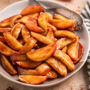 Plate with cinnamon sugar apples and serving utensil.