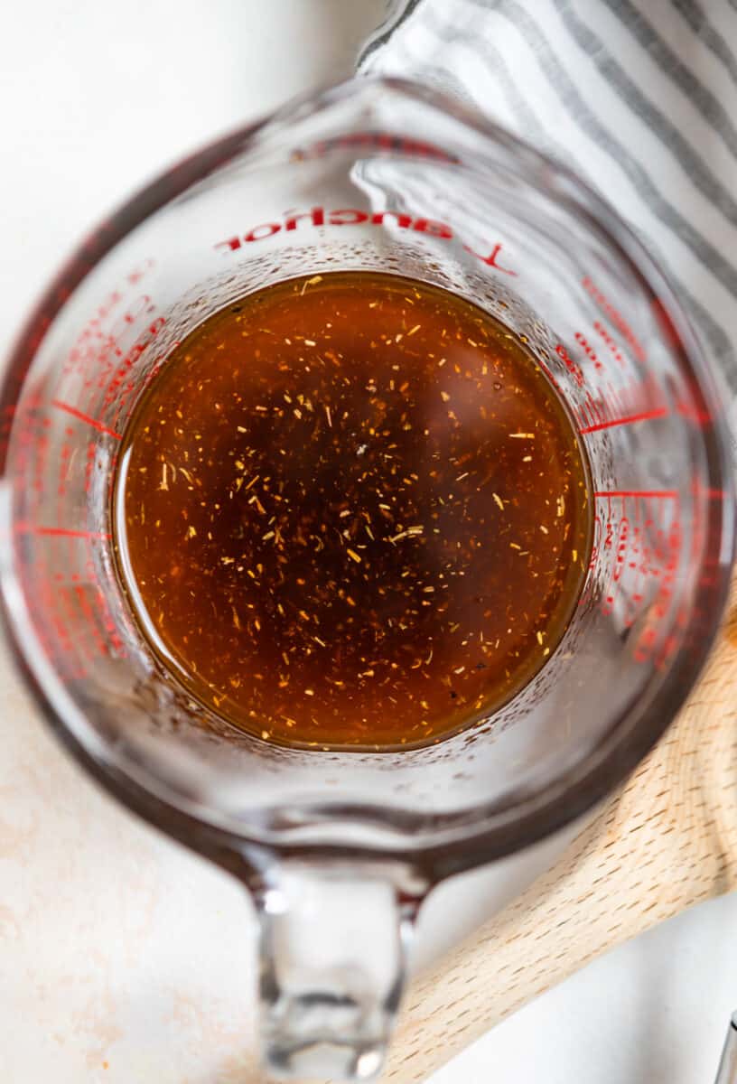 Sun-dried tomato vinegar dressing in measuring cup.