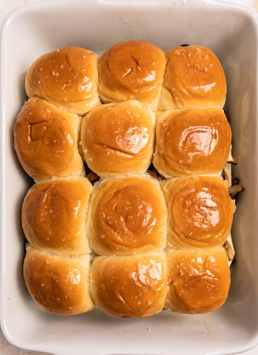 Buttered tops of rolls in baking dish.