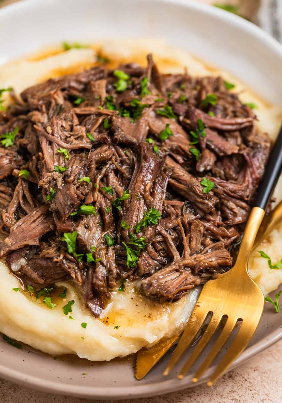 Dish with mashed potatoes topped with crock pot shredded beef.