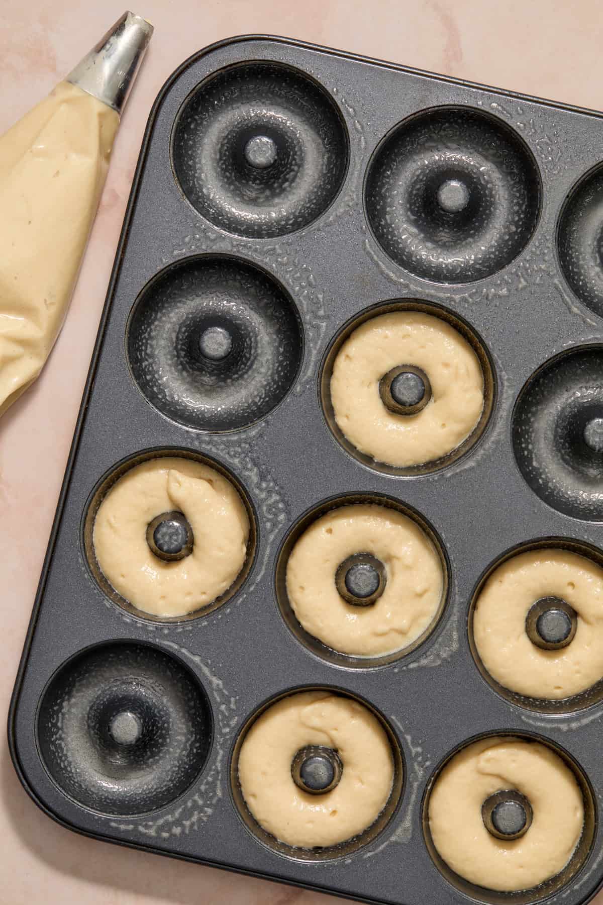 Donut pan with batter piped in.