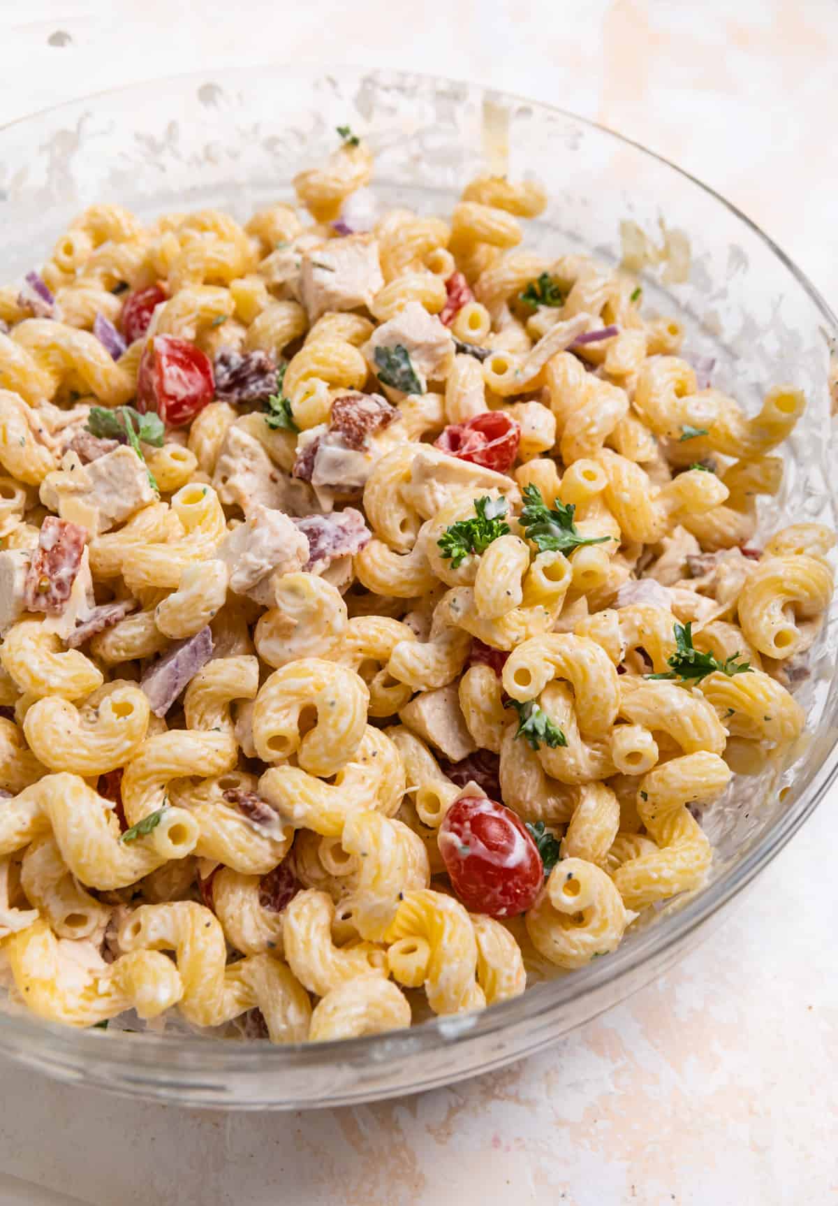 Chicken bacon ranch pasta salad tossed in ranch in mixing bowl