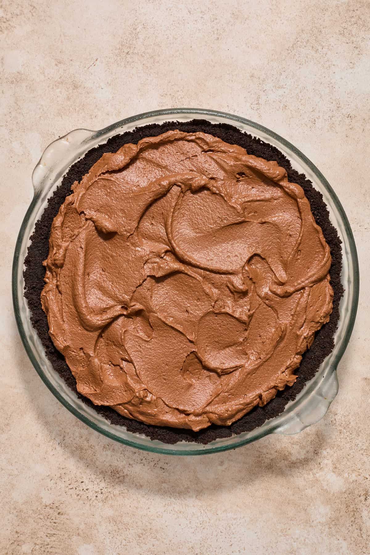 Chocolate pie filling spread into Oreo crust pie pan.