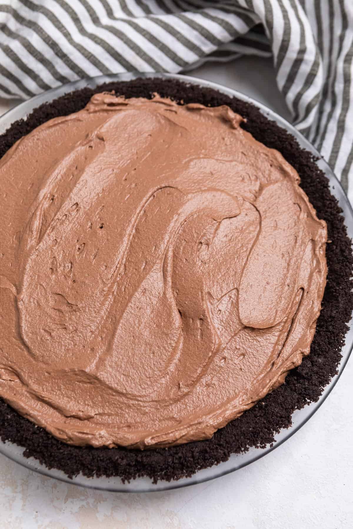 No Bake chocolate pie filling spread into pie pan with Oreo crust.