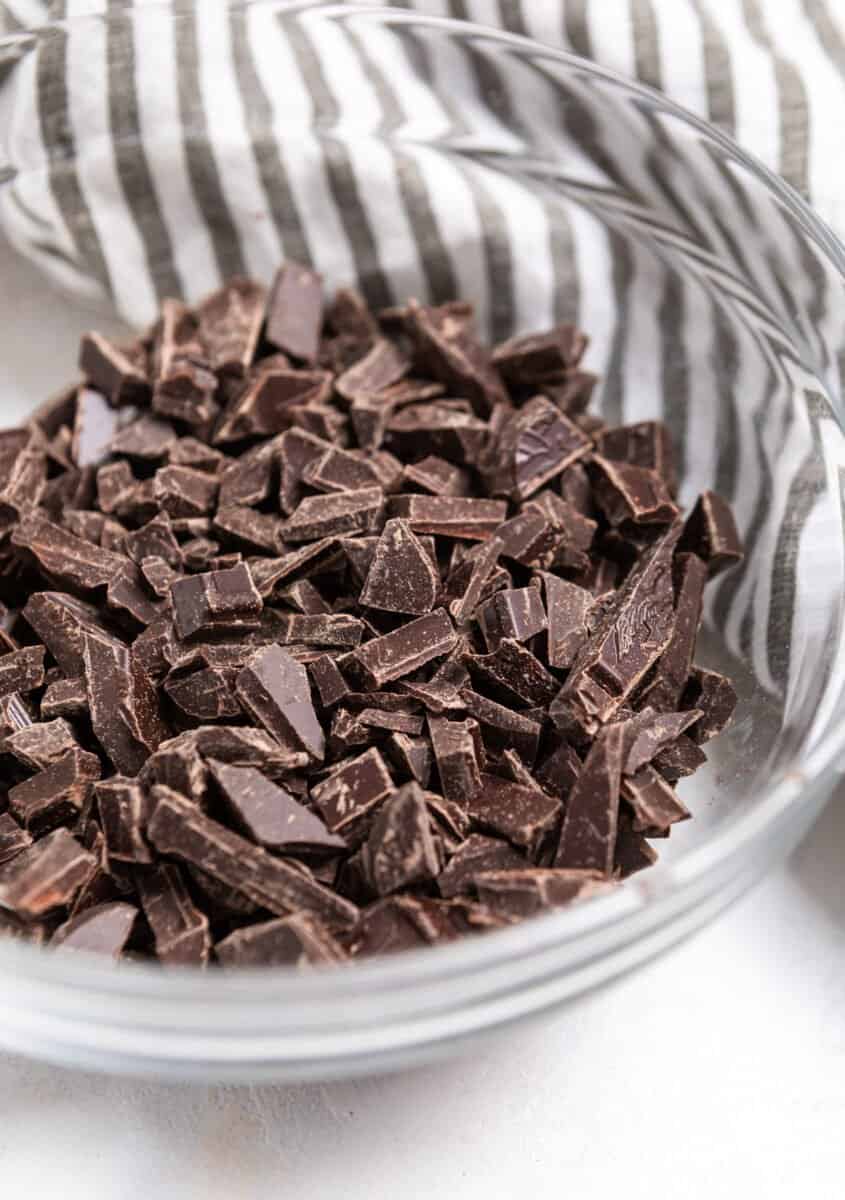 Chopped bittersweet chocolate in glass mixing bowl.