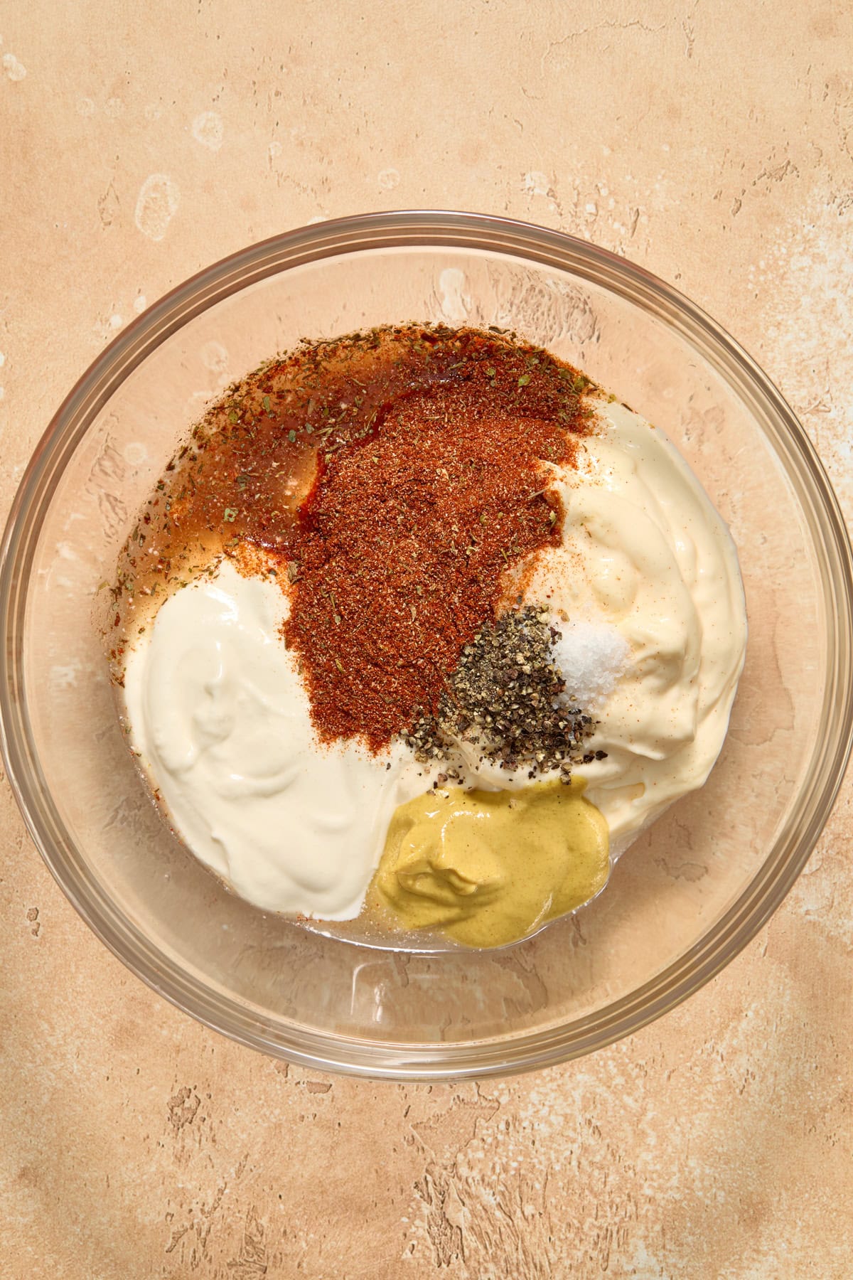 Mayonnaise, apple cider vinegar, spices and other ingredients in bowl before mixing. 